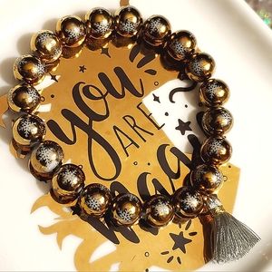 Beautiful electroplated glass bead gold ❄️ print stretch bracelet w/ tassel.